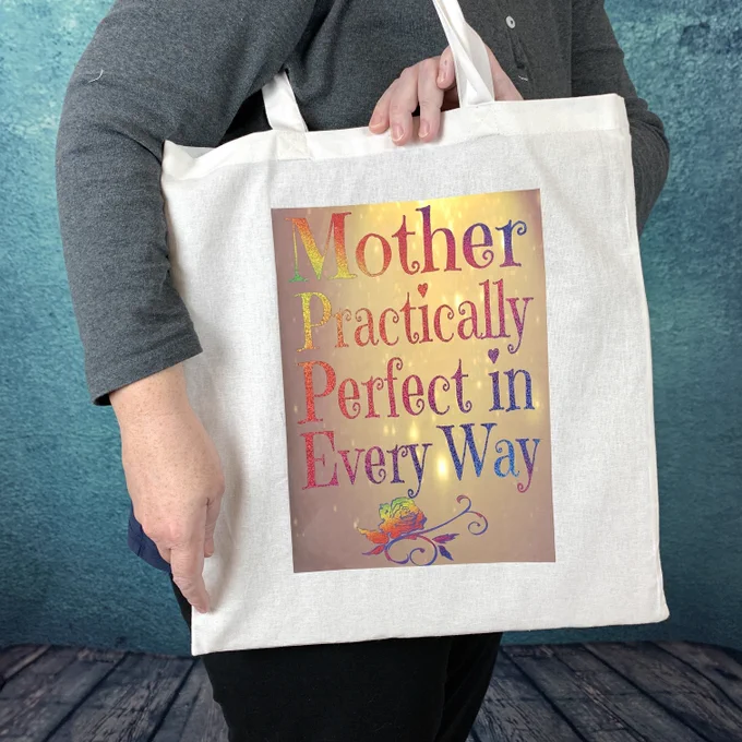 Eco Cotton Tote Bag printed with Mother Practically Perfect in Every Way being held by person in front of a blue wall and wooden floorboard backdrop