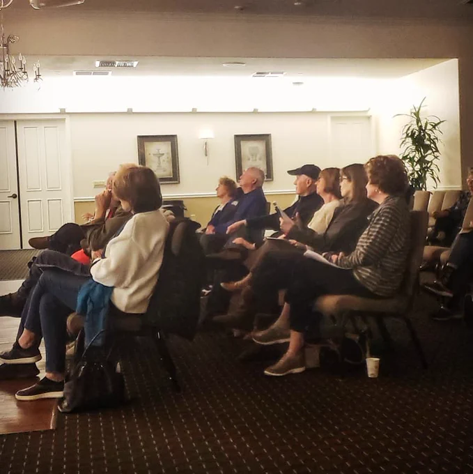 A crowd of people sitting in chairs.