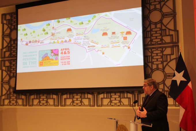 Festival organizer reviews festival grounds layout as projected on the screen behind him