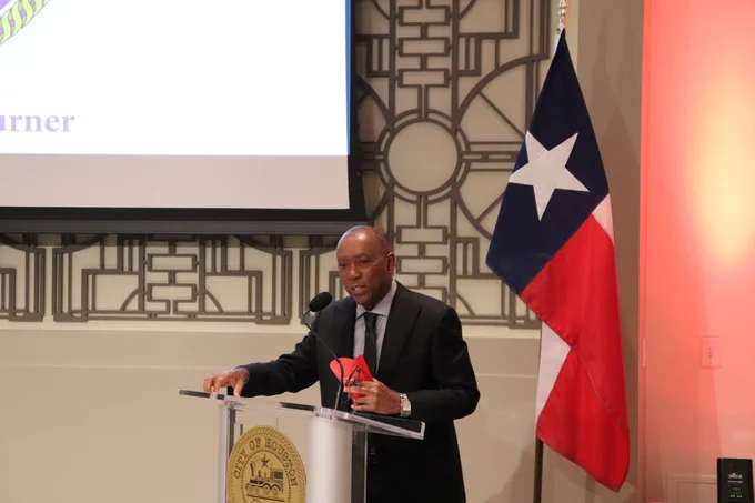 Mayor speaks from podium holding his french fries