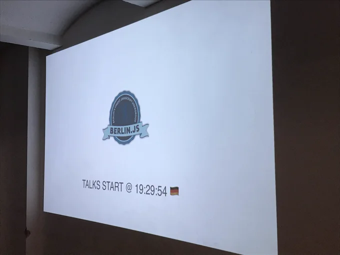 A slide that says “TALKS START @ 19:29:54 🇩🇪”.