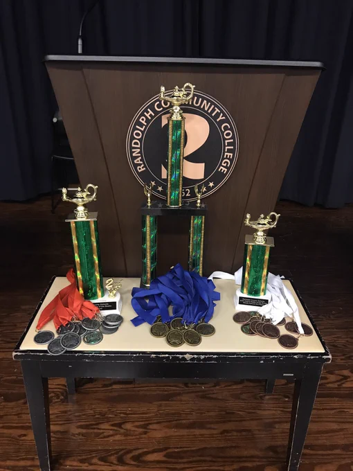 Three trophies and medallions on a stand.