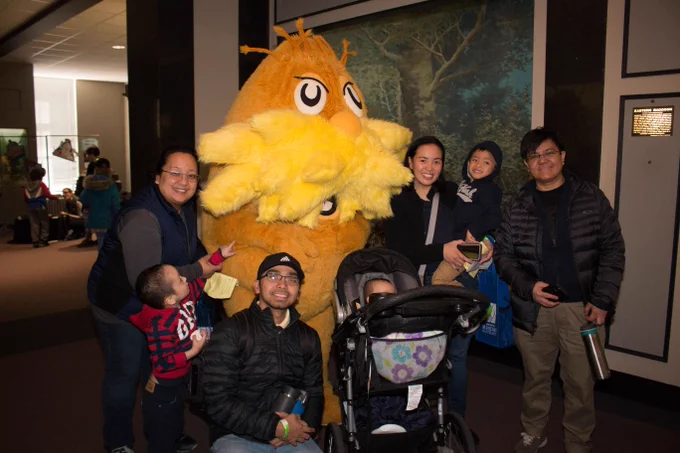 A group of people pose with the Lorax in the Springfield Science Museum.