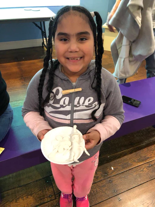 A girl shows off her sculpture of a flower and the Cat in the Hat in the Amazing World of Dr. Seuss Museum.