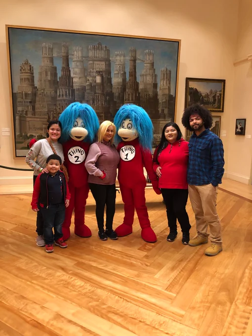 A group of people pose with Thing 2 and Thing 1 in Blake Court of the D'Amour Museum of Fine Arts.