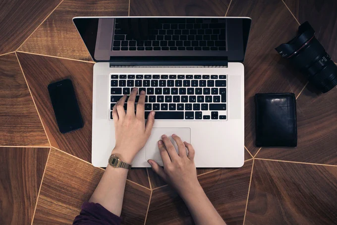 Hands working on a MacBook computer. Photo by Fabian Irsara on Unsplash