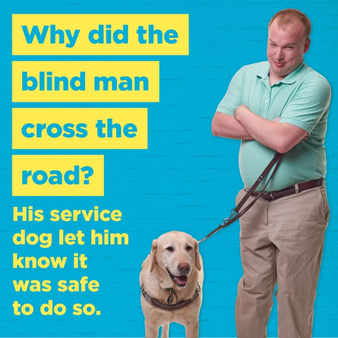 [Image Description: Jared Price, a man with short blonde hair, is standing in front of a bright blue brick wall. His arms are crossed, and he is smiling at the camera with his head tilted down slightly. In one hand, he holds the leash to his service dog, a yellow lab named Middleton. Highlighted in yellow text, it reads: Why did the blind man cross the road? His service dog let him know it was safe to do so.]