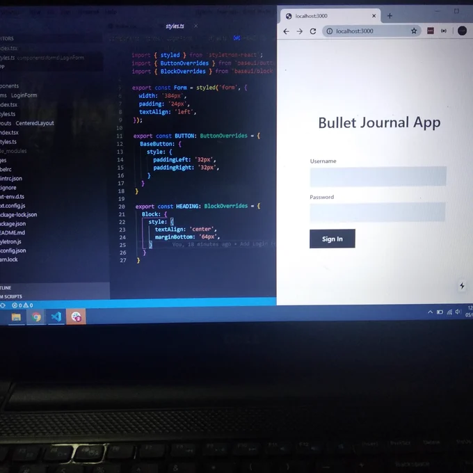 A laptop with a code editor and browser opened on its screen.