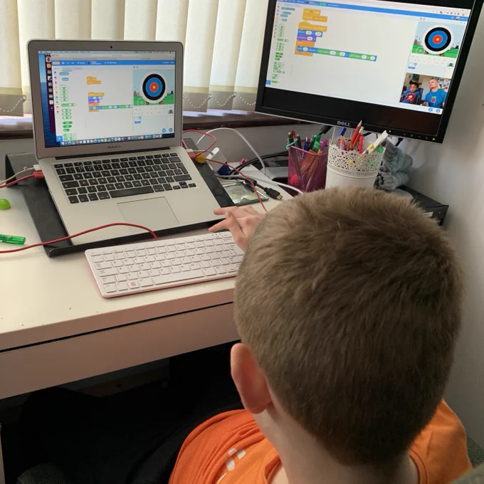 A boy engaging in digital making at home using Scratch