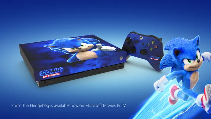 A custom Sonic The Hedgehog Xbox One X Console sits in front of a blue background. Sonic is posing in the bottom right corner. Photo reads: Sonic The Hedgehog is available now on Microsoft Movies & TV 