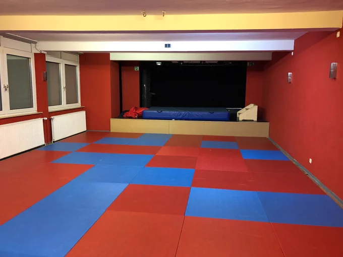 Raum mit Sportmatten und Bühne