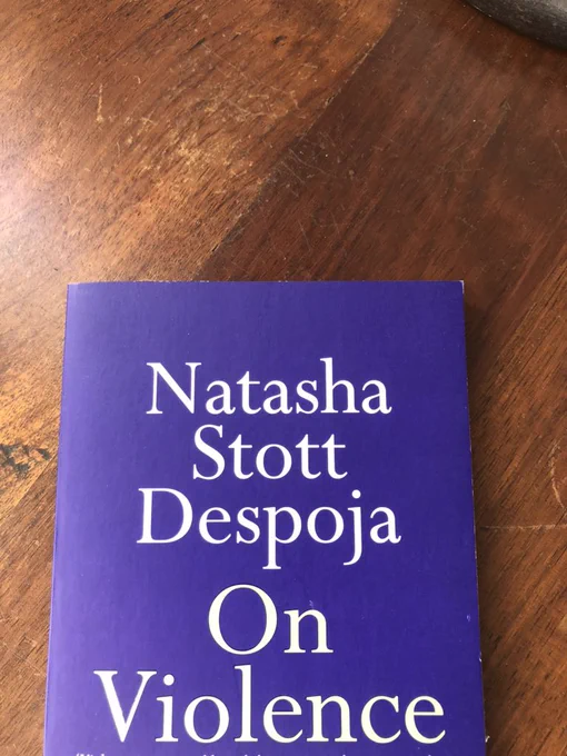 Front cover of book entitled “Natasha Stott Despoja On Violence”. Book cover is purple and is lying on a wooden table.