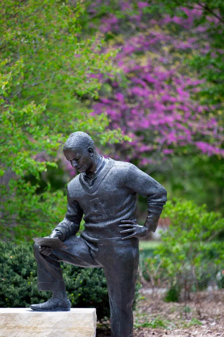 Christopher Bennett's Jack Trice sculpture with a backdrop of spring colors.