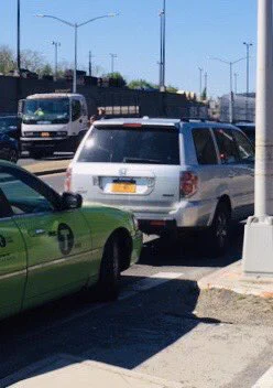 A green taxi and a gray for-hire vehicle on line
