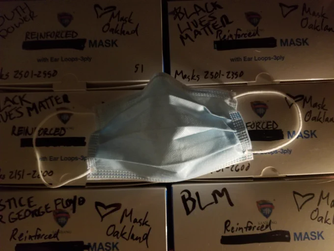 A surgical mask on a dark background of mask boxes w dramatic lighting