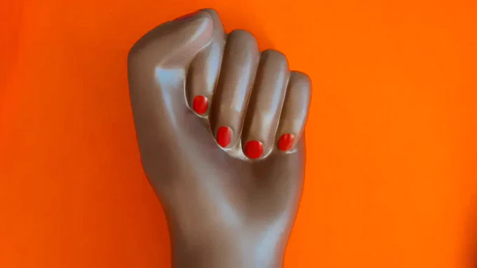 Brown power fist on bold orange background.