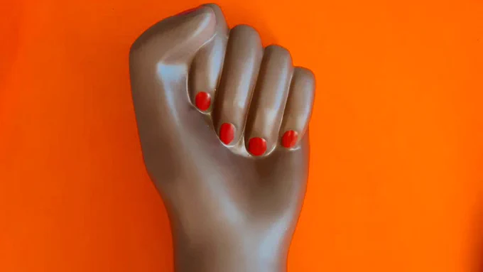 Black power fist on orange background