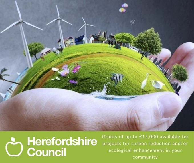 A hand holding a globe of countryside with wildlife and wind turbines. Graphic text - Grants of up to £15,000 for new projects which will deliver carbon reduction and/or ecological enhancement in your community