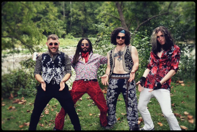 Dead Humor Poses In Front Of A Massive River Demonstrating Their Gargantuan Phallic Endowments Before Playing A Private Show