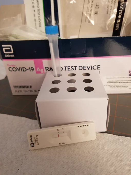 Rapid antigen test kit and negative results on Covid-screening test device.