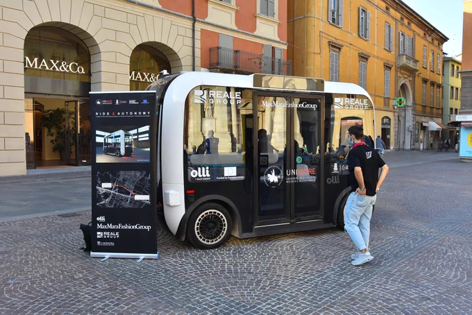 Reggio Emilia resident examines Olli, the electric, autonomous vehicle manufactured by Local Motors.