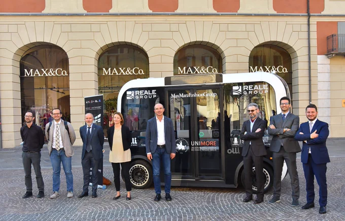 Project leaders stand in front of Olli during the public introduction of the Ride To Autonomy project.