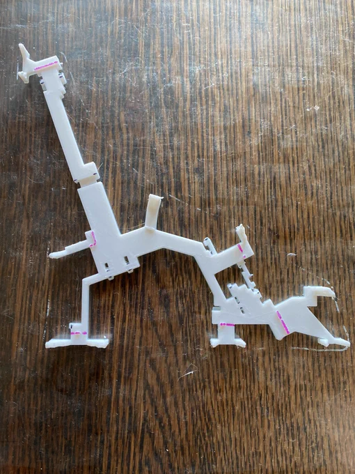 A 3d model of Union Square station with no labels but showing stairs, fare arrays, corridors and mezzanines in white filament. It's stuck to a glass printing plate with a wooden surface showing underneath.