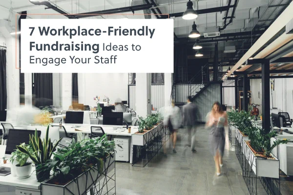 An open office plan with a few potted plants here and there. People with blurred out faces are coming and going. 