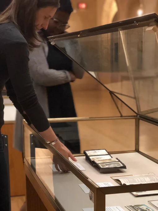 Photo of folks putting things in an exhibition case in Wilson Special Collections Library