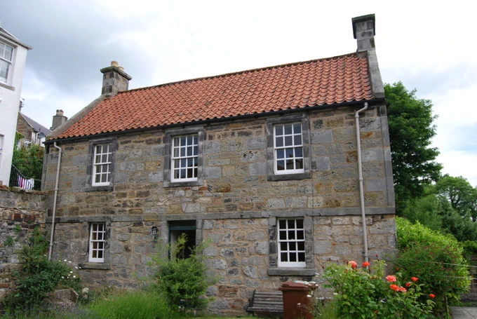 A traditional stone house with a pantile roof