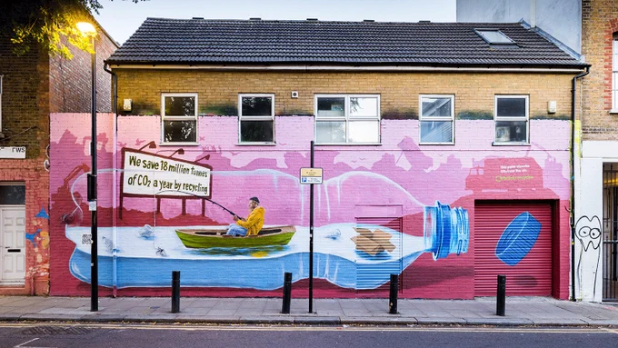The image shows a man in a boat, above him is a sign that says "We save 18 million tonnes of CO₂ a year by recycling".