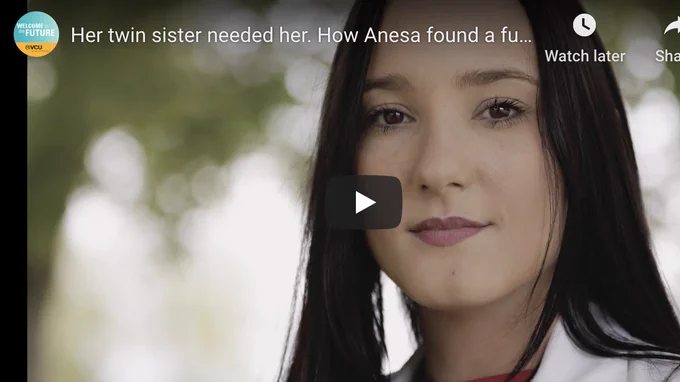 A video screen shows a young woman in a white coat.