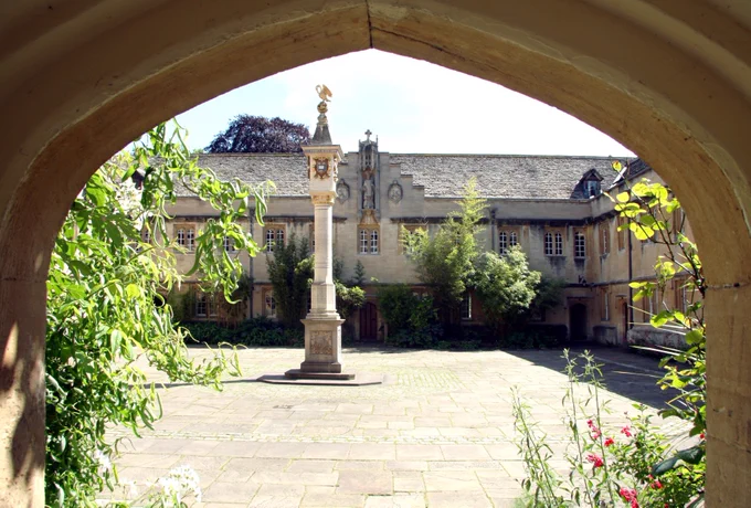 The entrance to Corpus Christi College. Through the sandstone doorway, there is a quad with the Pelican Sundial in the middle.