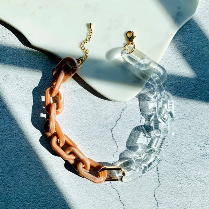 Chunky link chain necklace set against a moody stylish background.