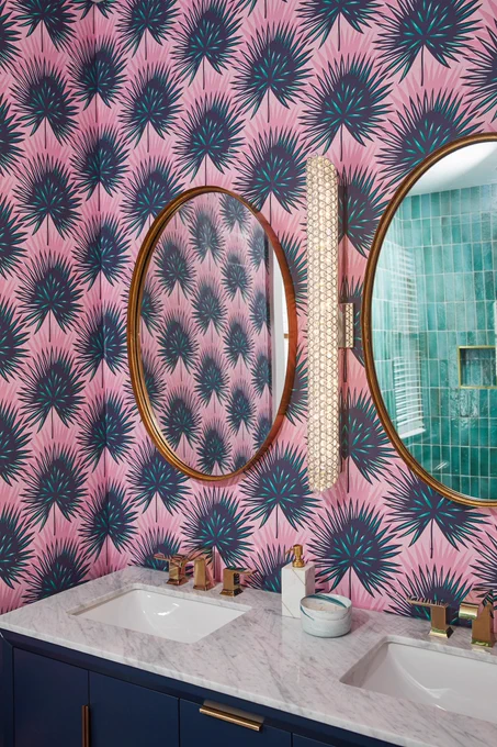 A Quoizel Infinity bath light is mounted between two mirrors at a bath vanity.
