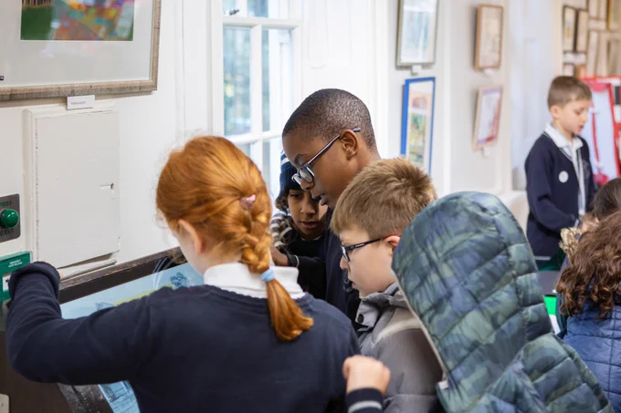 Five children gather round an interactive screen at a gallery at Lauderdale House.