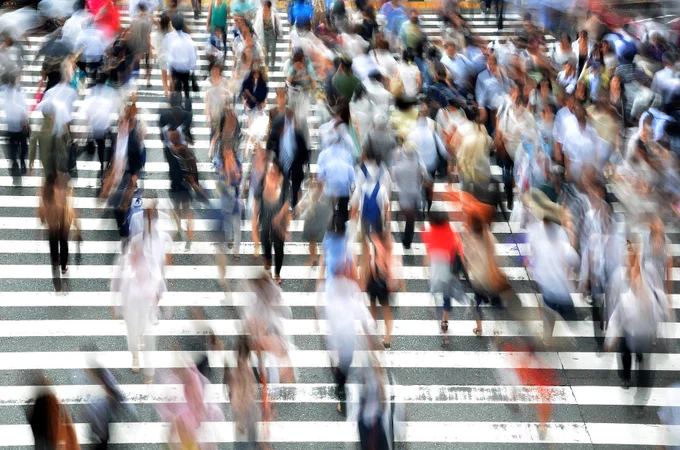 Image shows a blurred picture of busy people on a set of steps