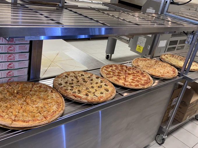 Fresh pizzas with a variety of toppings on a rack