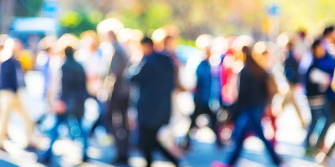 A blurry image of people walking in a crowd.