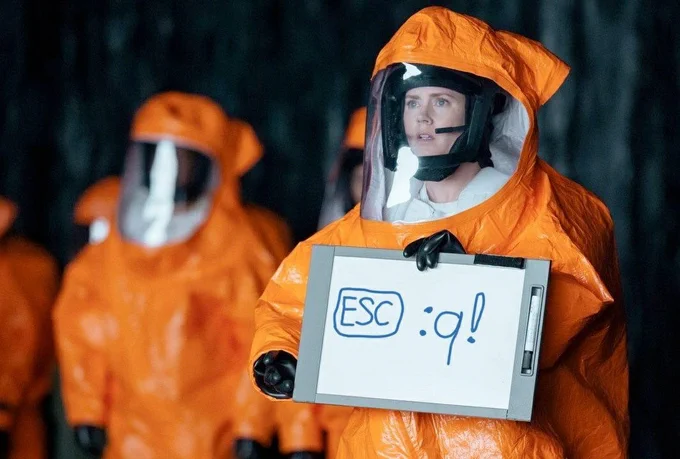 The woman holding up a whiteboard to let aliens know that to get out of vi(m) it's ESQ :q!
