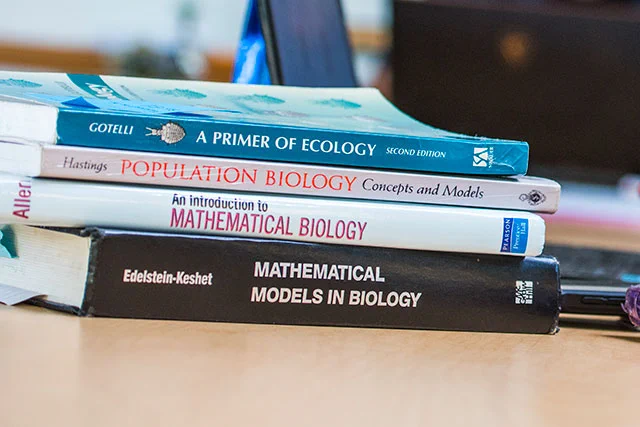 A stack of math and biology textbooks.