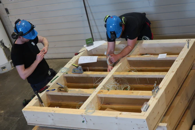 Two persons in a test hall, making preparations