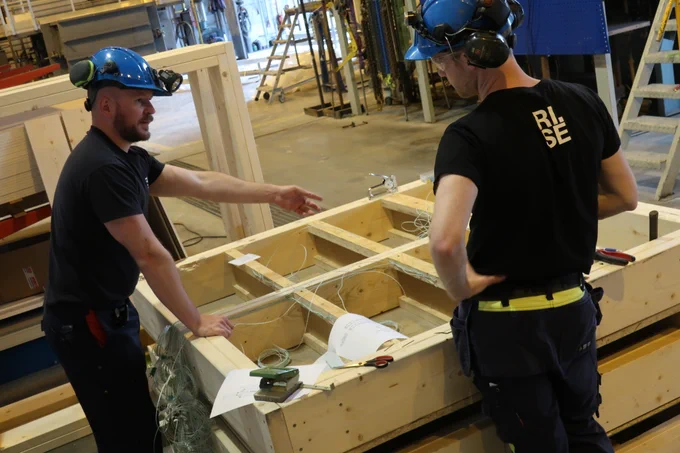 Two persons in a test hall, making preparations