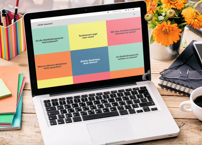 Das Bild zeigt MacBook auf einem Schreibtisch. Zu sehen ist die Website von meinem Projekt "nicht stumm!"