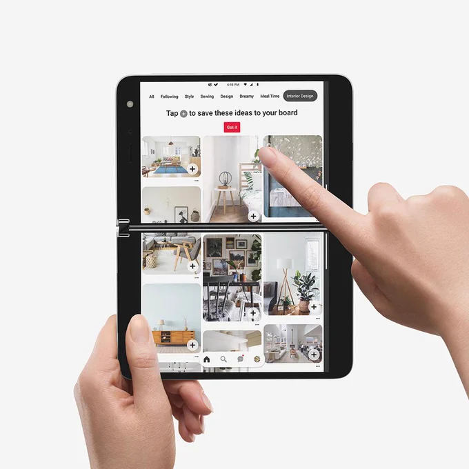 Surface Duo is horizontal with both screens showing Pinterest as a finger scrolls the page. 
