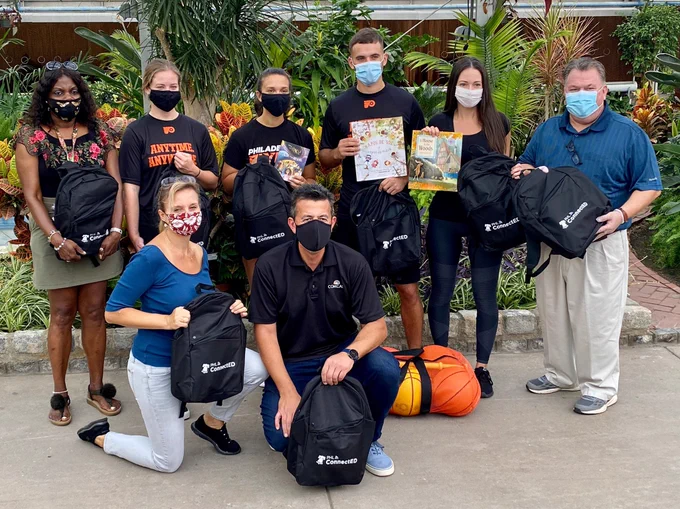 Group of volunteers pose with backpacks