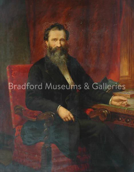 Portrait of Isaac Holden by Samuel Sidley, c. 1868. In Bradford Museums and Galleries collection. Portrait shows Isaac Holden as a middle aged man sat in a chair at a desk. 