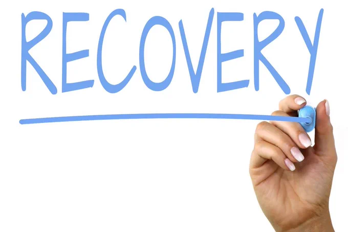 Image of a hand writing "Recovery"