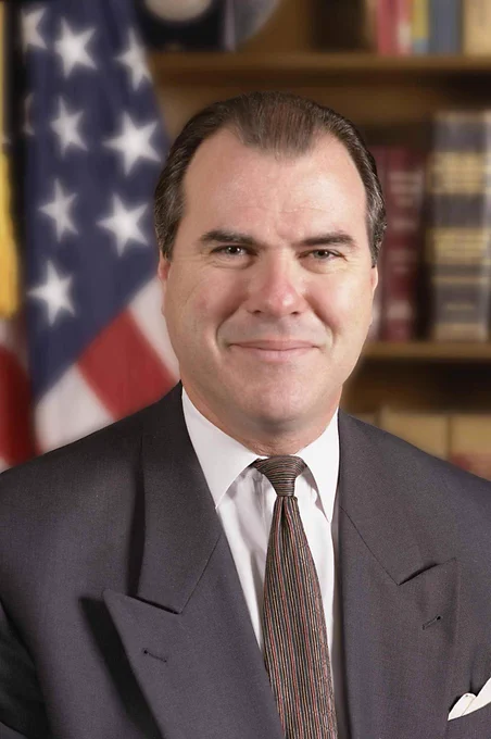 A headshot of retired Special Agent in Charge John O'Neill with an American flag in the background.