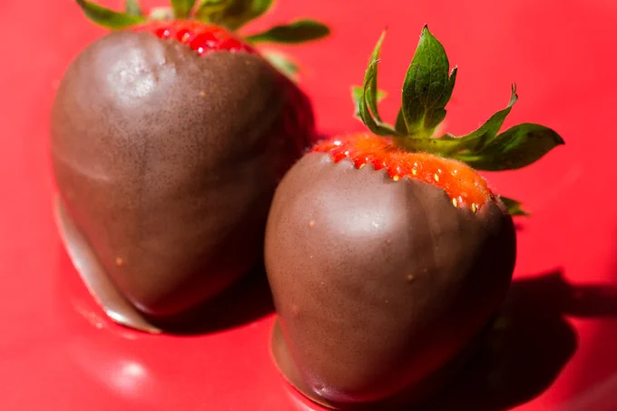 Chocolate covered strawberries on a red plate